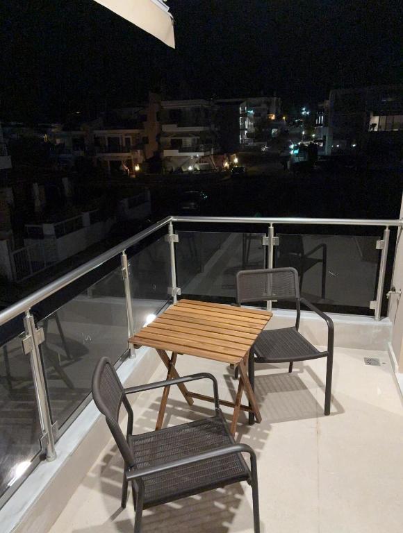 a wooden table and two chairs on a balcony at night at Affero Vita in Flogita