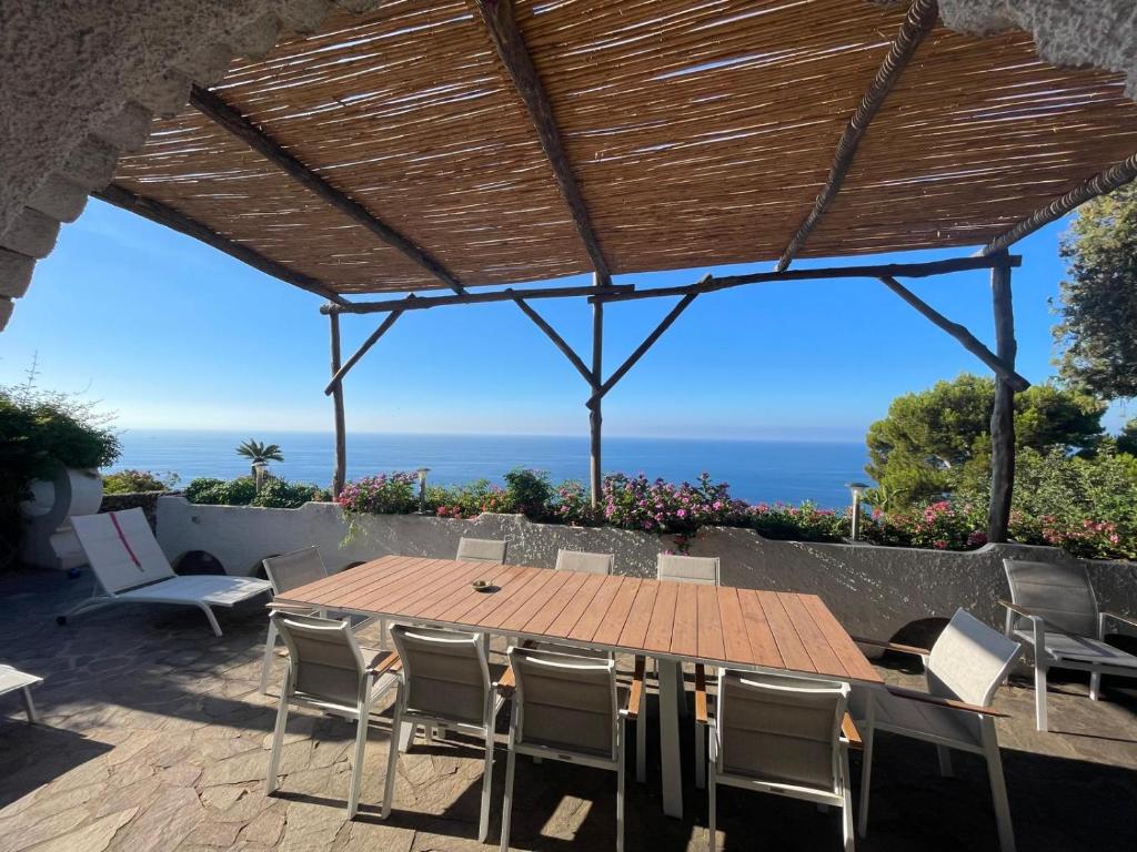a table and chairs on a patio with a view of the ocean at Villa La Birbirella in Conca dei Marini