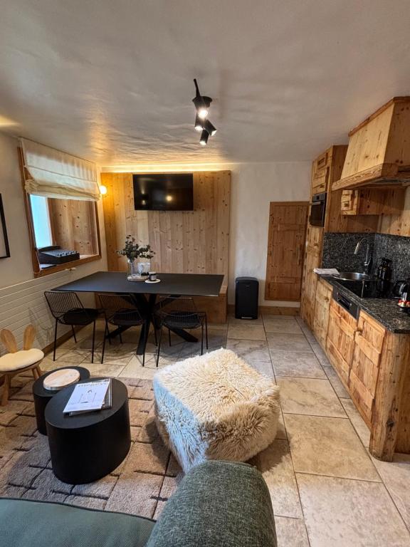 un salon avec une table et une cuisine dans l'établissement NEW Appartement CŒUR DU VILLAGE, à Praz-sur-Arly