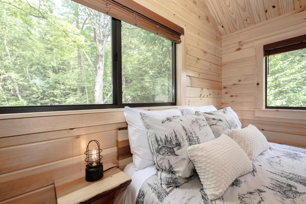 Un dormitorio con una cama con almohadas y una ventana. en PineHaus - Brand New Log Cabin at Harvard Brook, en Lincoln