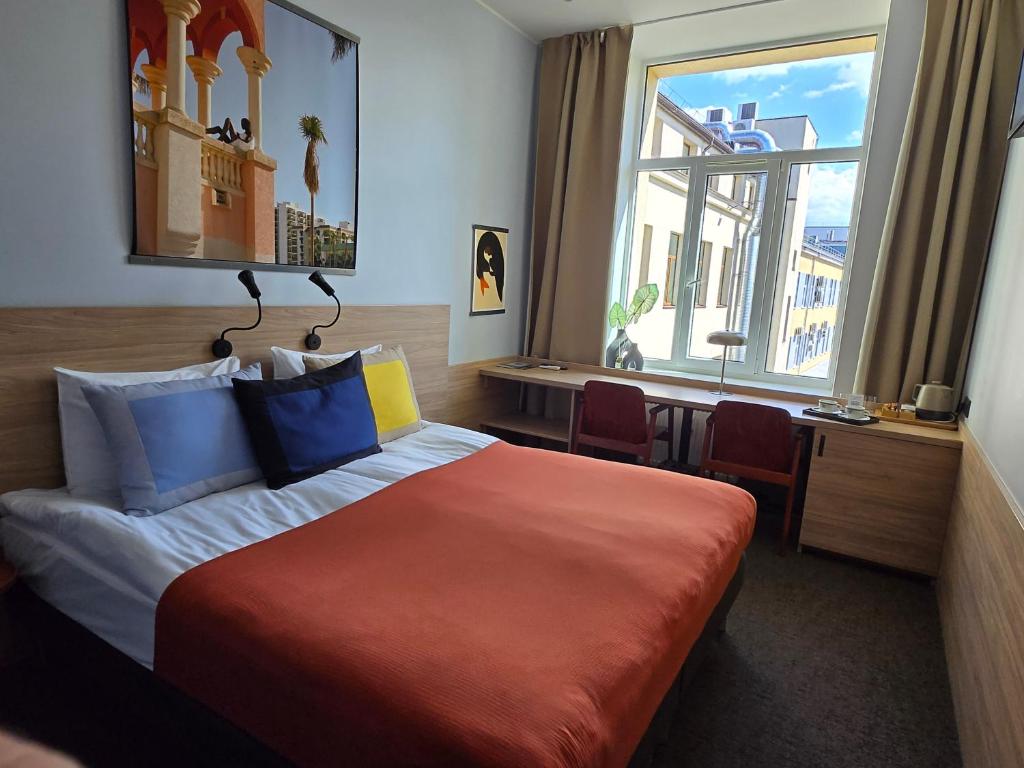 pokój hotelowy z łóżkiem i oknem w obiekcie Private Hotel Room in the Corner of Vilnius City Centre w Wilnie