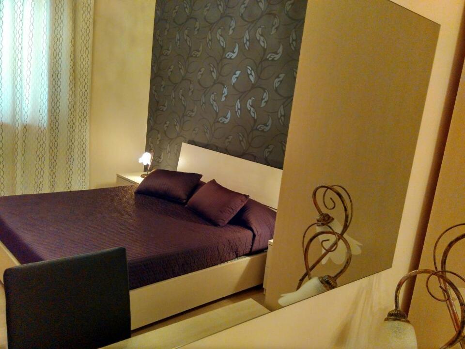 CaltavuturoにあるB&B Crocco D'Oroの小さなベッドルーム(紫色の枕が付くベッド付)