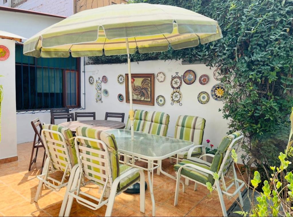 a table and chairs under an umbrella on a patio at Refugio del Sol in Chosica
