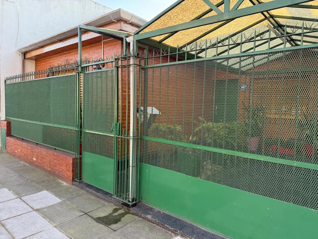 a green fence on the side of a building at Chalet Buenos Aires in Buenos Aires