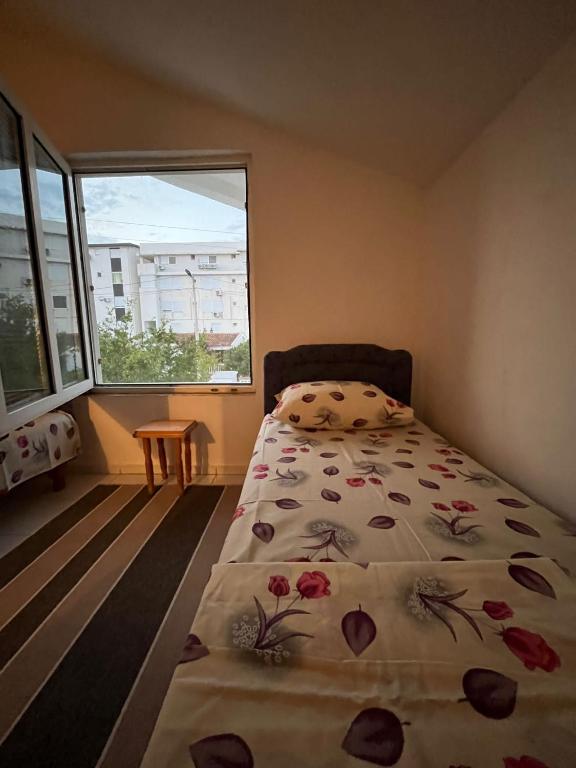 a bedroom with a bed and a large window at Apartman Tara in Donji Štoj