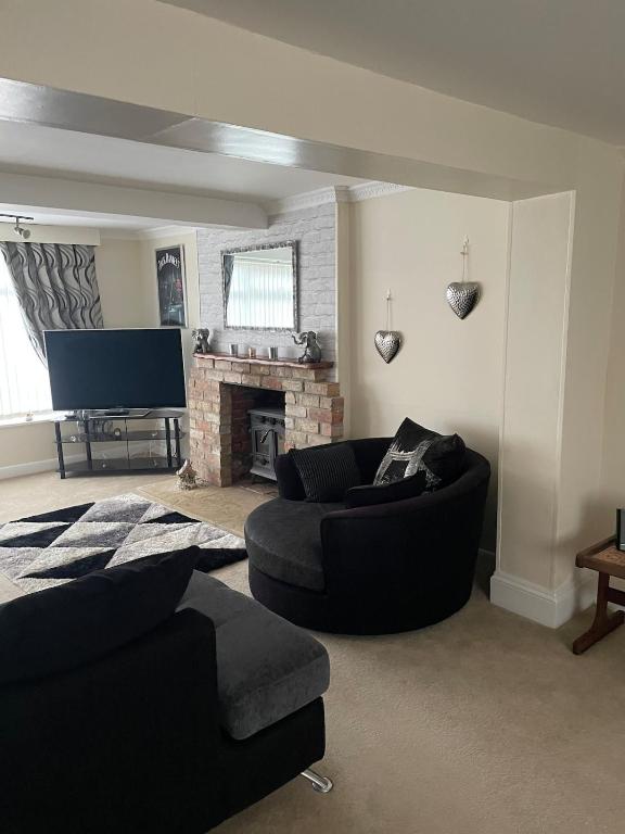 a living room with a couch and a fireplace at Large 4 bedroom house in Heckington
