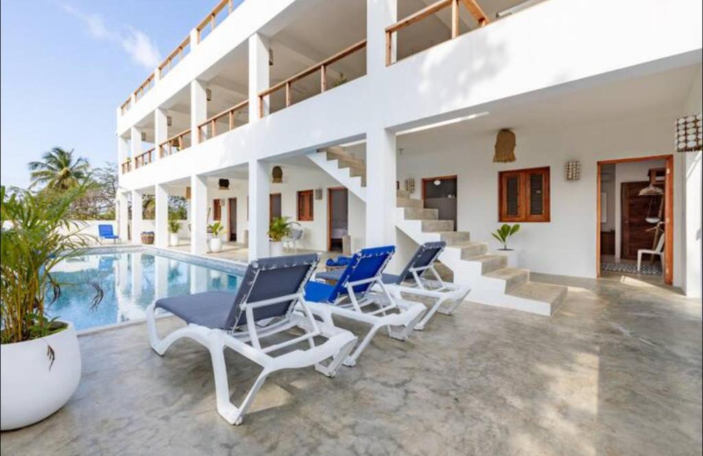 a villa with chairs and a swimming pool at Casa flor - 16 pax, vista al mar, 2 min de la playa in Las Galeras
