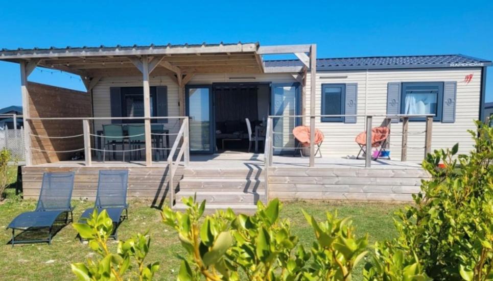 une maison avec une terrasse et des chaises dans l'établissement Mobile-home bord de mer, au Guilvinec