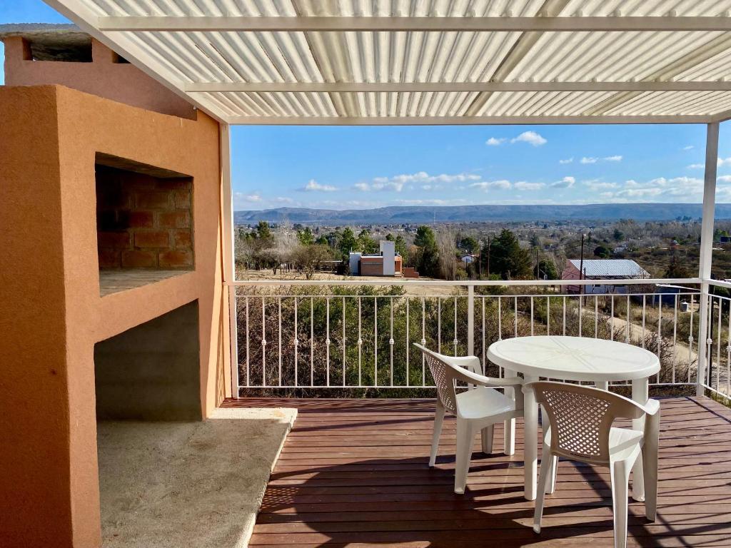 a patio with a table and chairs on a balcony at Clomplejo MUNAY con piscina y parking in Villa Cura Brochero