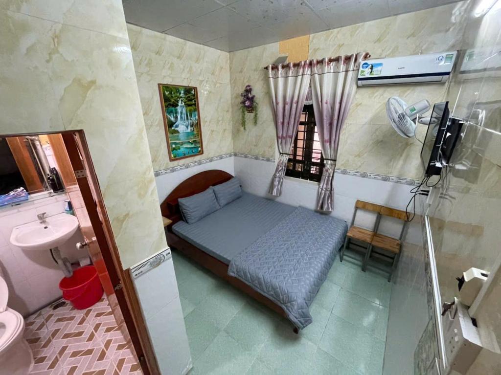 a small bedroom with a bed and a sink at Bảo Hoàng HomeStay in Con Dao
