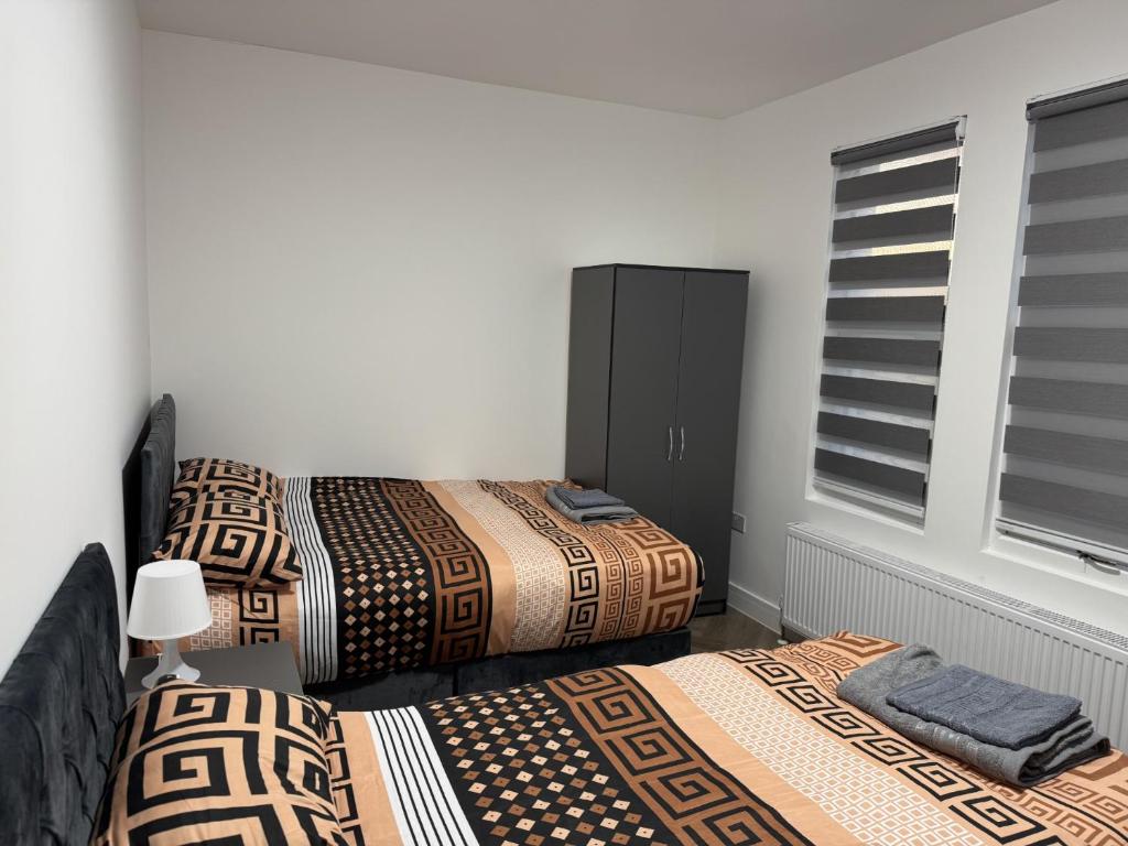 a bedroom with two beds and a window at Old Ridgeway Hotel in Chingford