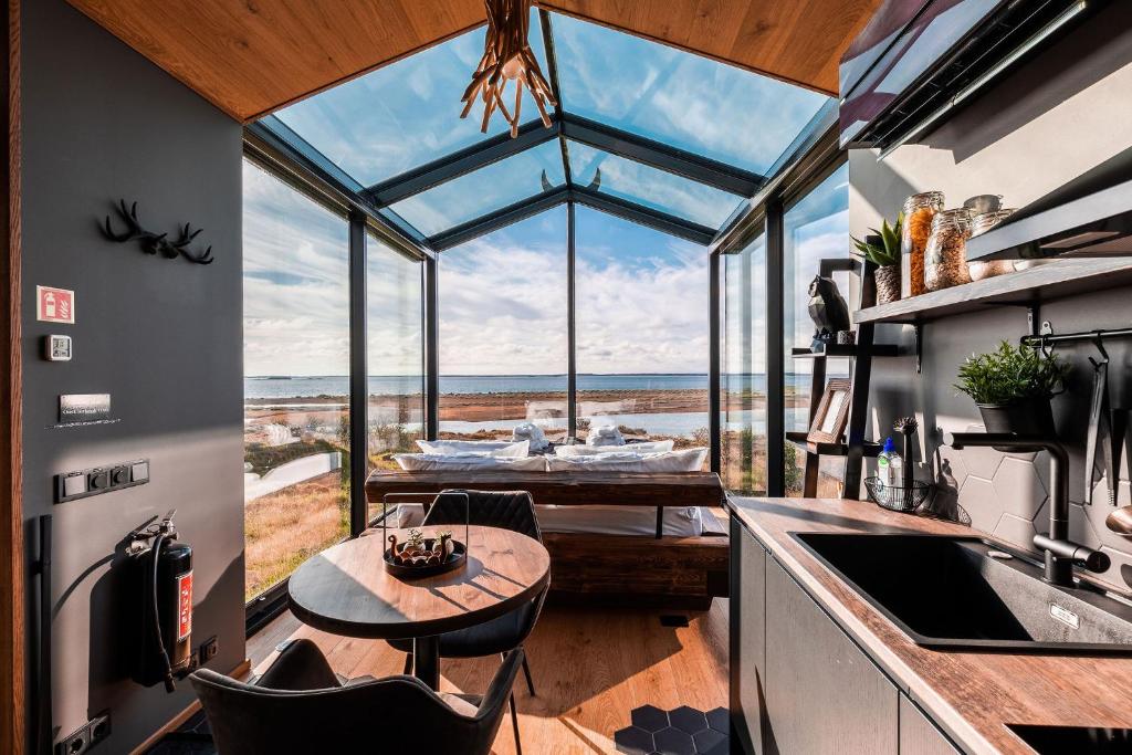 Panorama Glass Lodge WEST في أكرانيس: مطبخ مع طاولة ونافذة زجاجية كبيرة