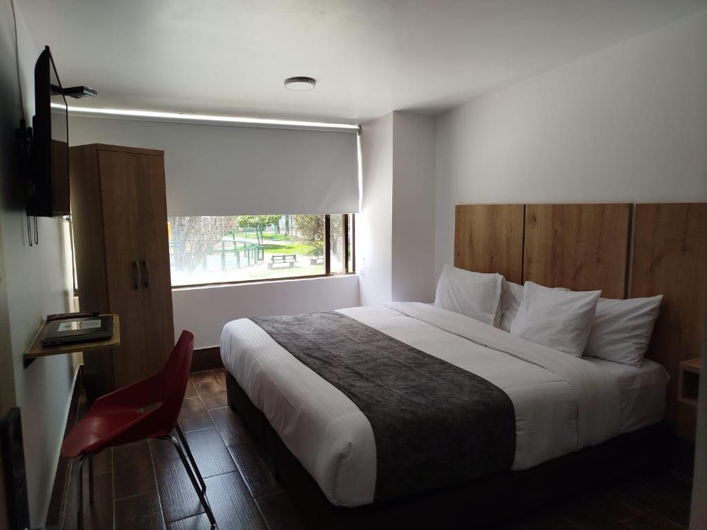 a hotel room with a bed and a window at Aw Hotel Ariston Embassy in Bogotá