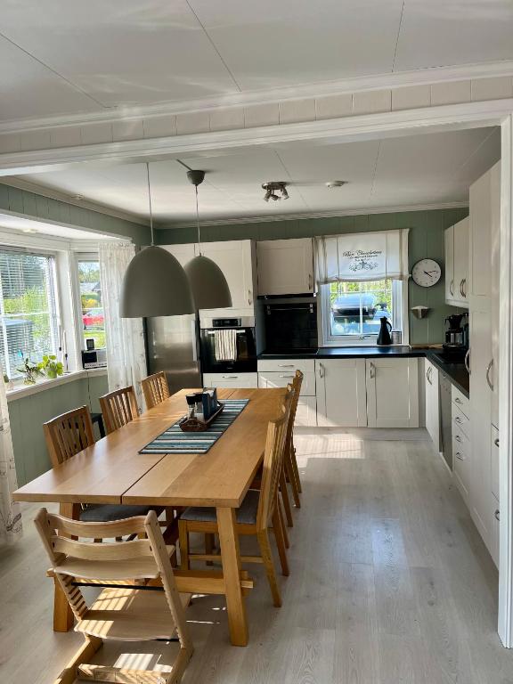 a kitchen with a wooden dining table and chairs at Kronstad in Alta