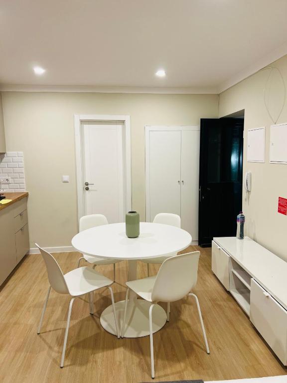 a kitchen with a white table and chairs in a room at Apartamento Central - Lisbon in Lisbon