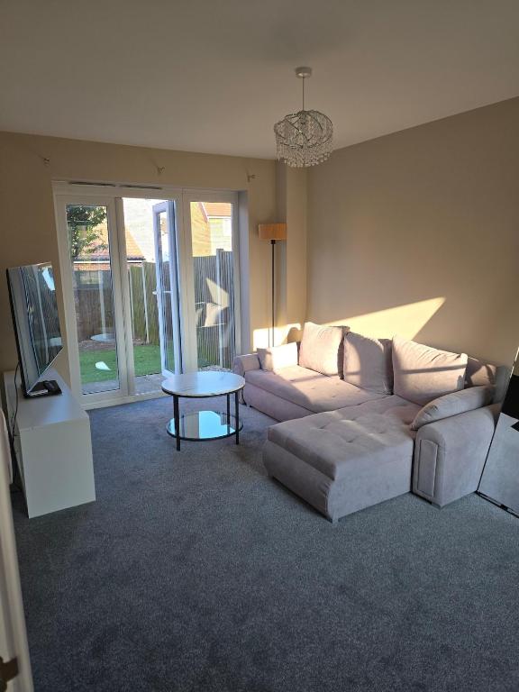 a living room with a couch and a table at Spacious & Homely Colchester Stay-Great Location in Hythe