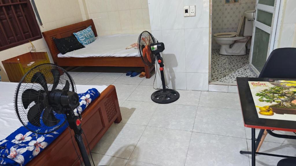a room with a room with a bed and a fan at Hotel KIỀU GIANG in Nga Sơn