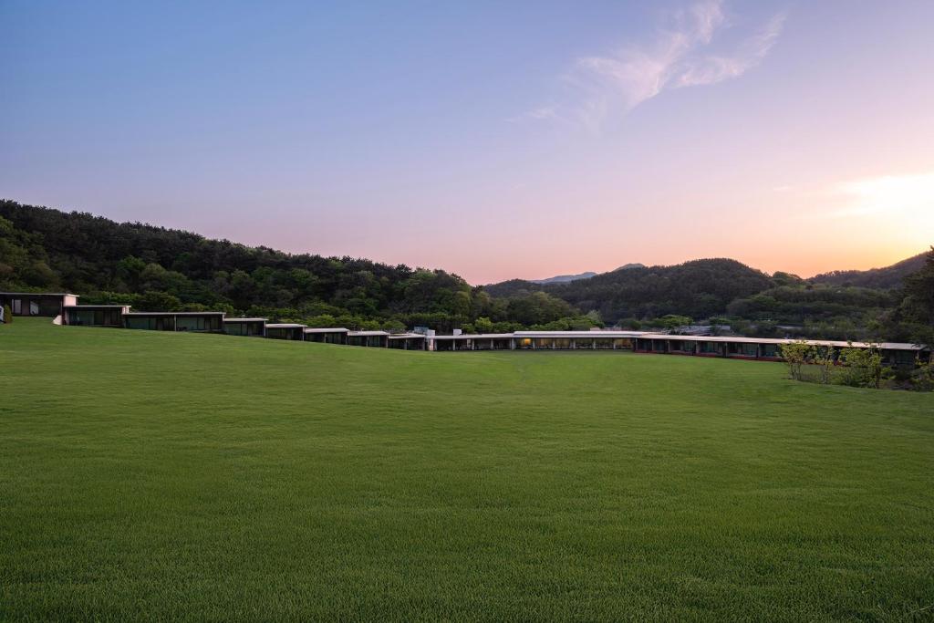 a large green field with a building in the background at Haeundae Beach Restfield in Busan