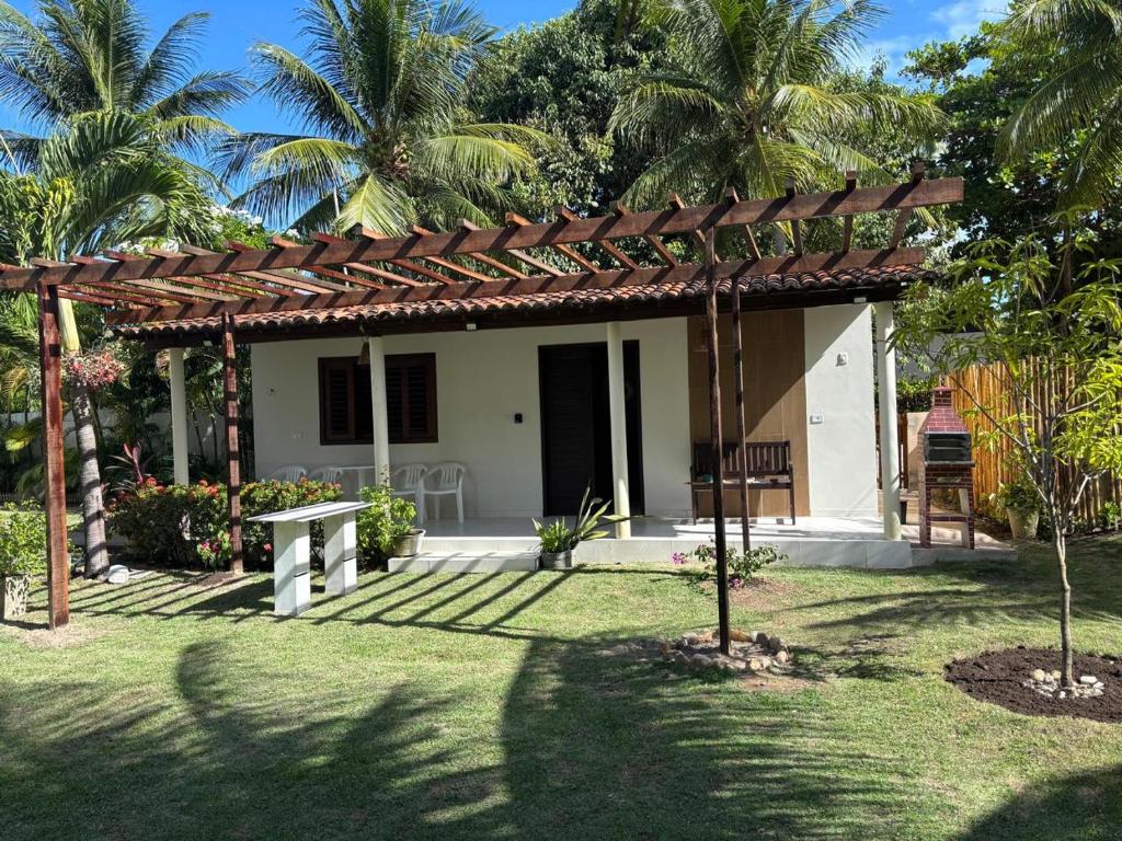 a house with a pergola in a yard at Flat Xareuzinho - Praia Antunes in Barra Grande