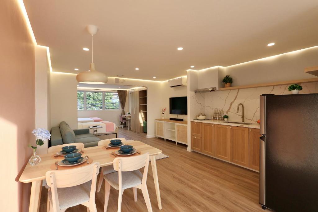 a kitchen and living room with a table and chairs at Alesea Suites Surf Town in Dalumpinas Oeste