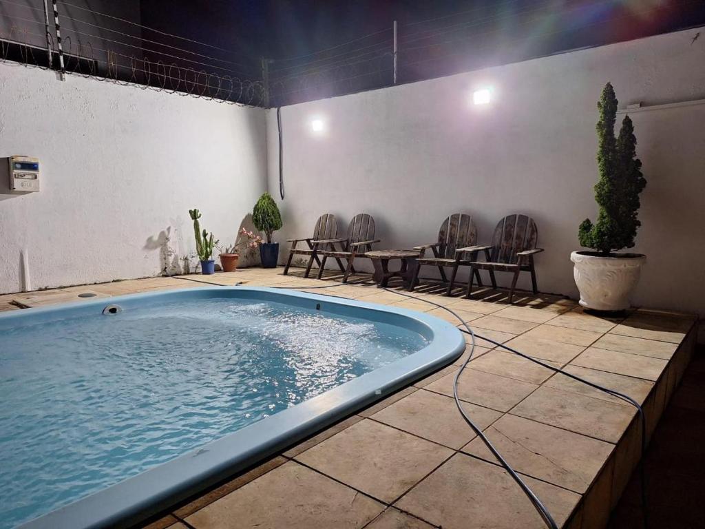 einen Pool in einem Zimmer mit Stühlen und einem Tisch in der Unterkunft Casa pra Temporada 2km da praia in São Luís