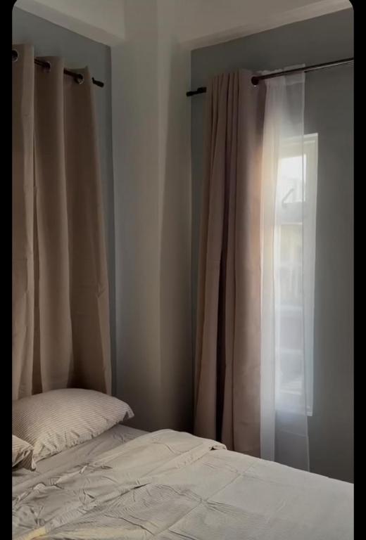 a bedroom with a bed and a window with curtains at La Casa Guillermo 
