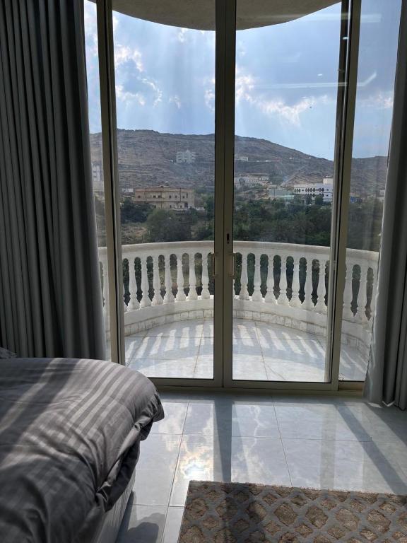 a bedroom with a view of a balcony at شقق الاطاولة المفروشة in Āl Ţāwilah