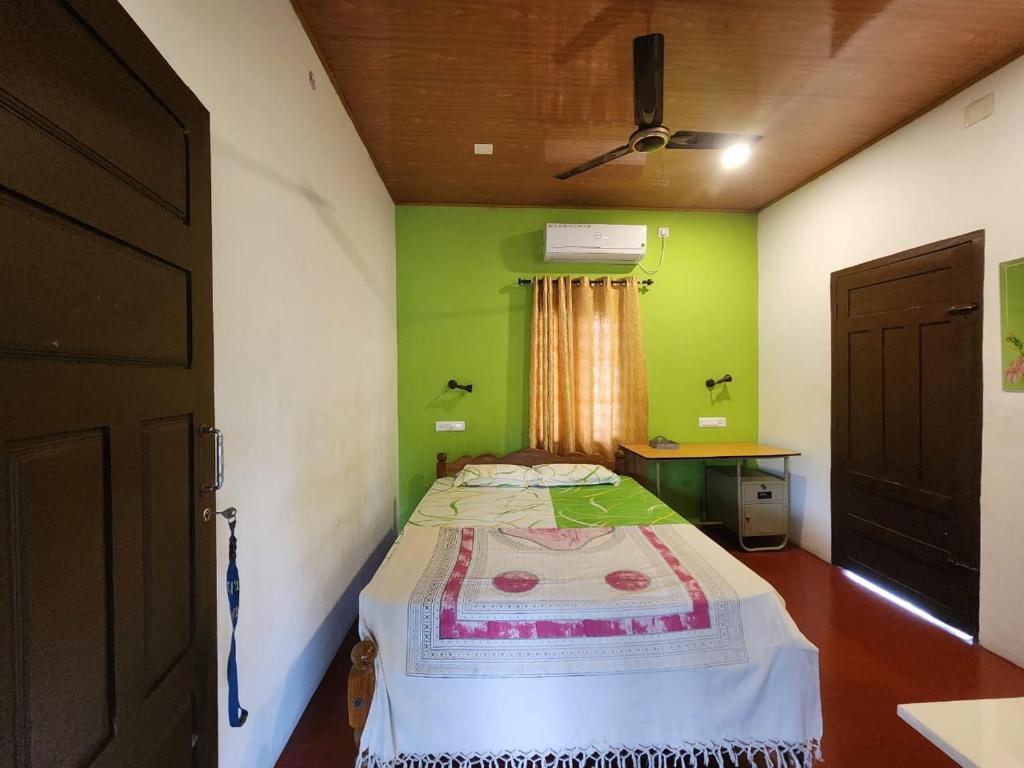 a bedroom with a bed in a room with green walls at Marari sea gold in Mararikulam
