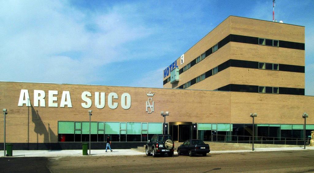 a large building with cars parked in front of it at Hotel Área Suco in Quintana del Puente