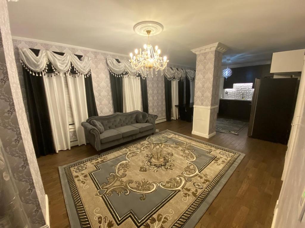 a living room with a couch and a chandelier at Luxury apartment near Old Orchard Beach in Biddeford