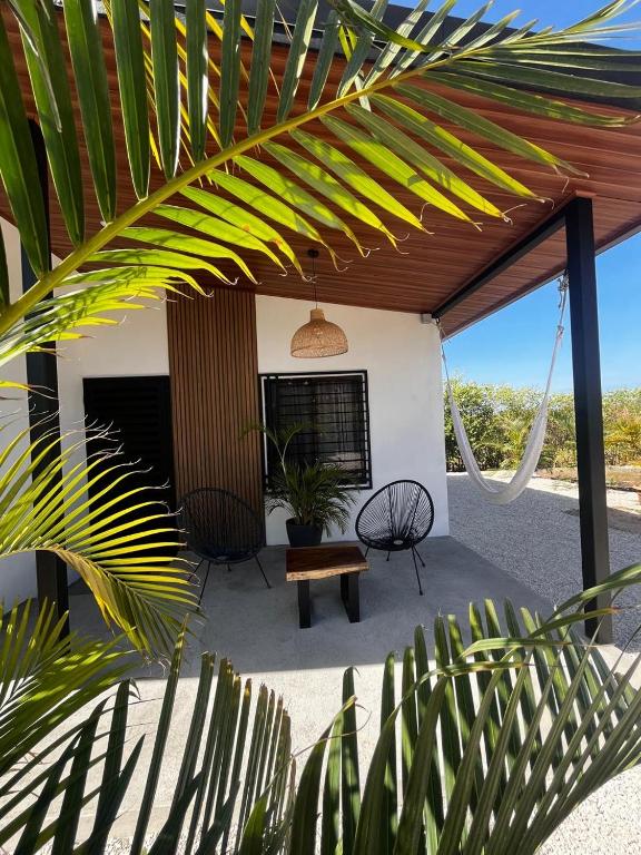 a patio with a table and a bench under awning at Apartamento 1, cerca de la playa, naturaleza y paz in Santa Cruz