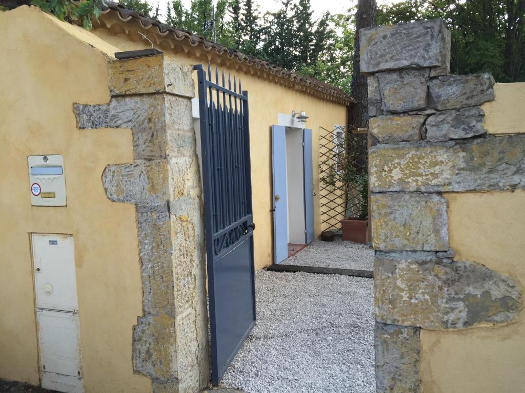 - l'entrée d'un bâtiment avec un portail et un mur en pierre dans l'établissement Charmant Studio Brignoles, à Brignoles
