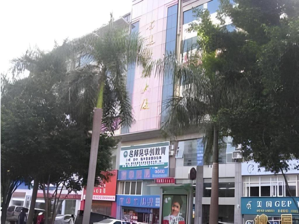 a building on a street with trees in front of it at Xiang Mei Hotel - Jingtianbei Branch in Shenzhen