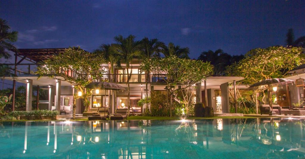 a villa with a swimming pool at night at Chimera Villas in Seminyak