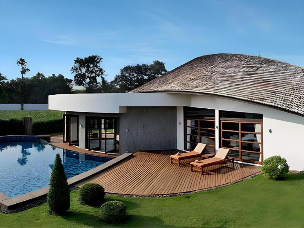 una casa con tetto di paglia e piscina di Azaya Villas Resort a Chiang Mai