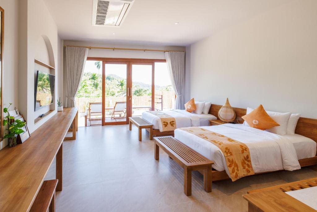 une chambre d'hôtel avec deux lits et un balcon dans l'établissement Ban's Diving Resort, à Koh Tao