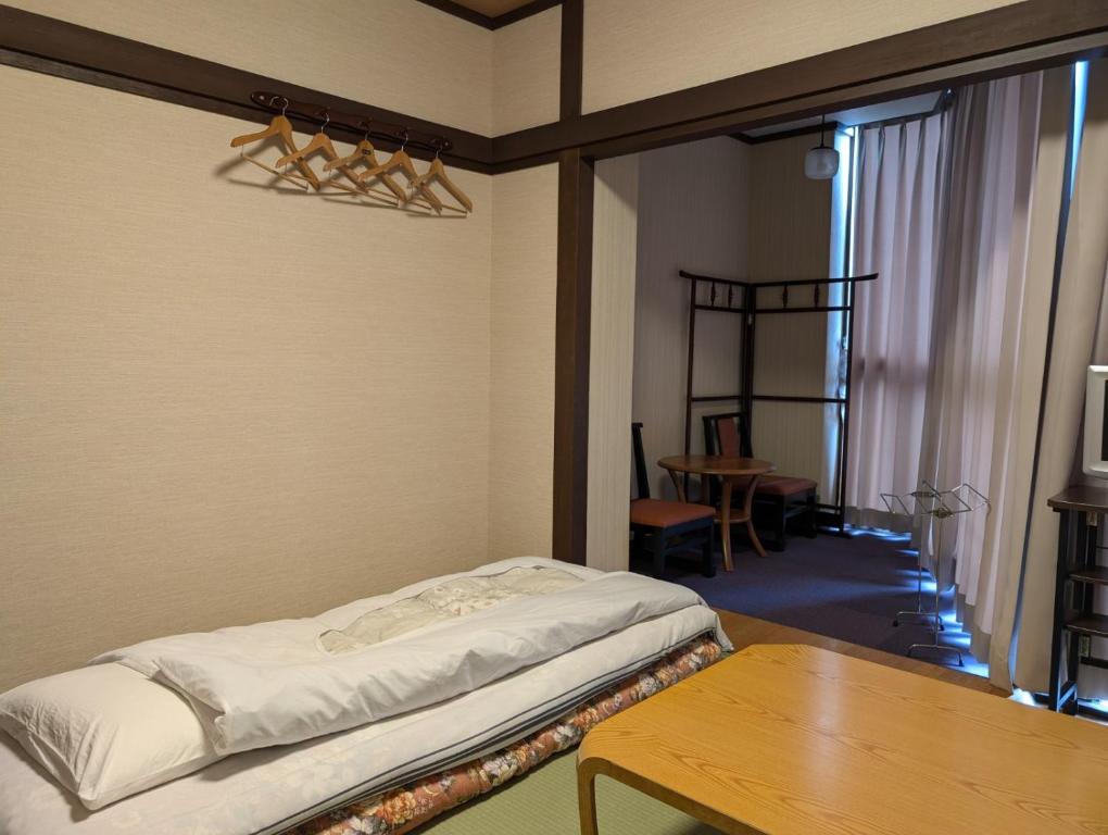 une chambre avec un lit et une table en bois dans l'établissement Oyado Nozawaya, à Nozawa Onsen