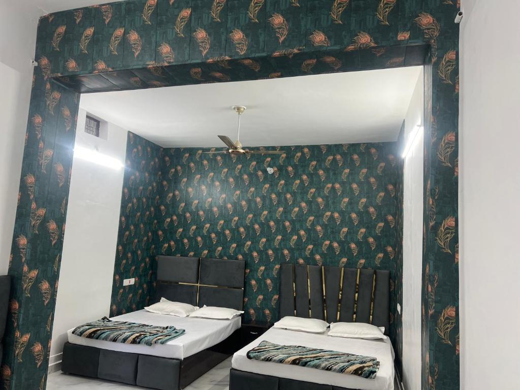 two twin beds in a room with a wall at Hotel Sankul Villa, 100 Meter Away Saryu River & Ram Ki Paidi, Lux Stay in Ayodhya