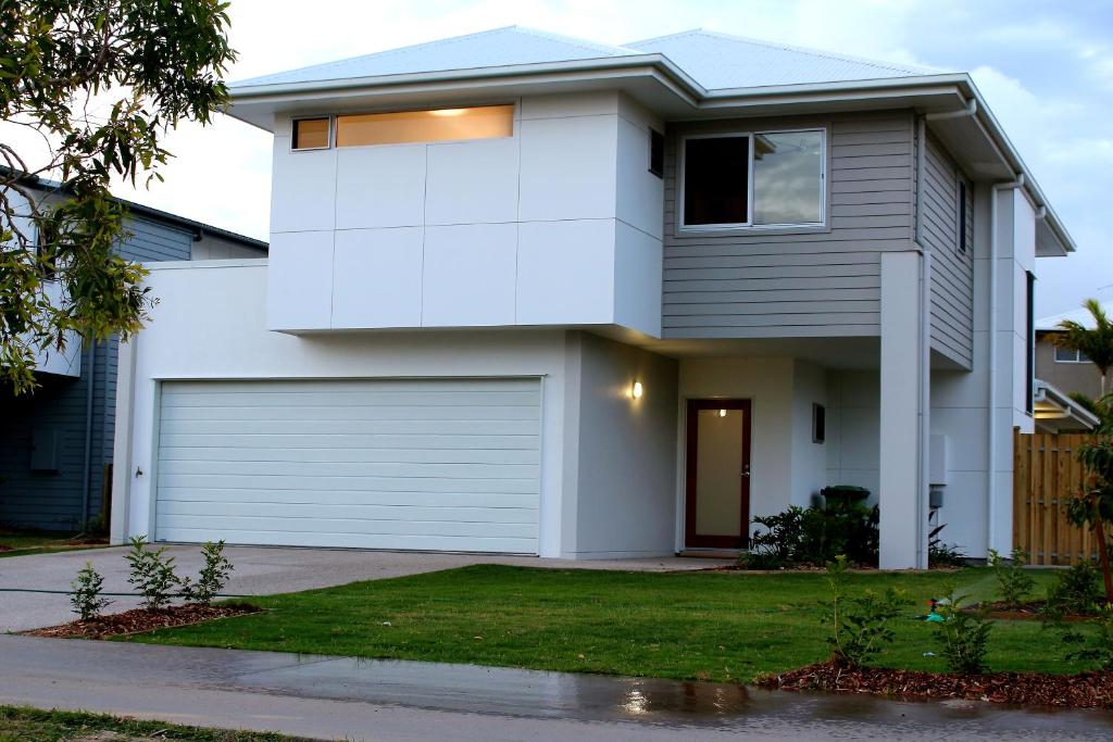 una casa bianca con garage di Petrie Beach Holiday Home a Mackay