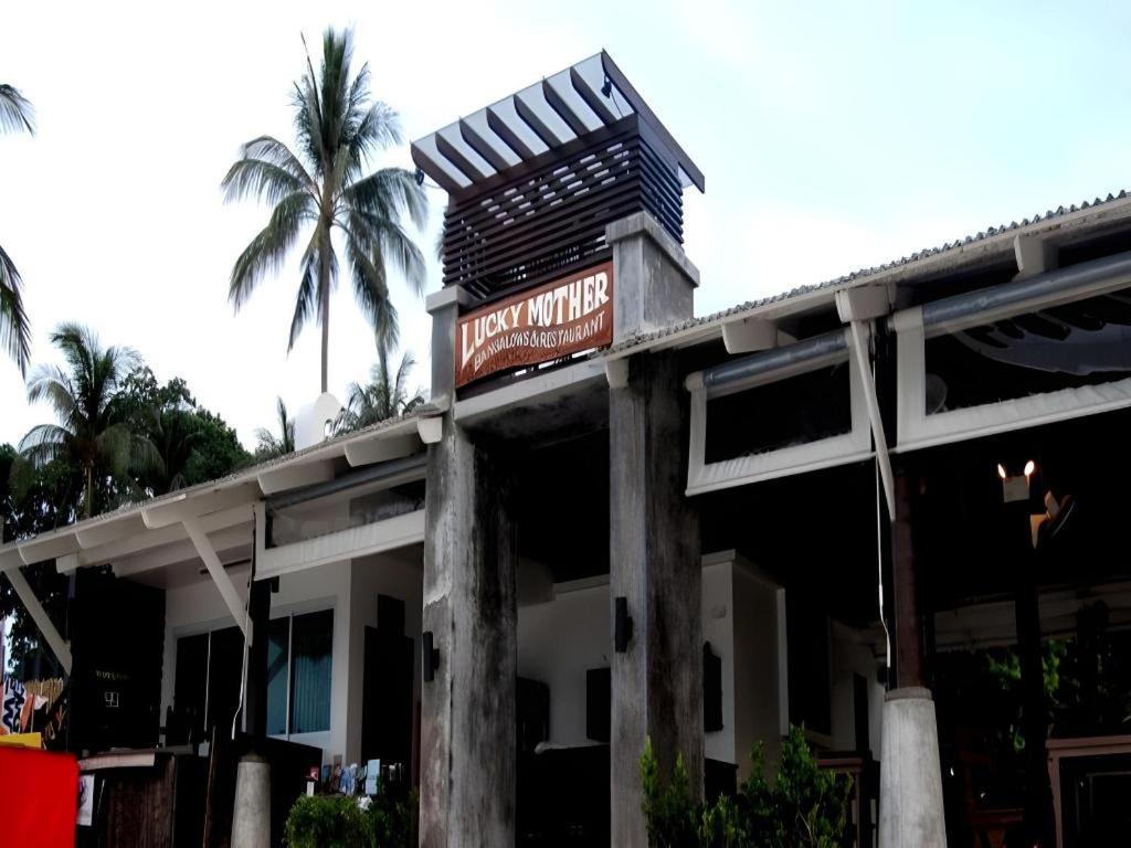 um edifício com uma placa com uma palmeira em Lucky Mother Bungalow em Chaweng Noi Beach