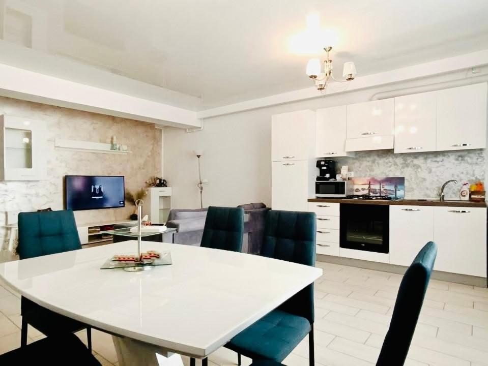 a kitchen and dining room with a white table and chairs at Apartament 2 camere Mamaia Nord in Mamaia Nord
