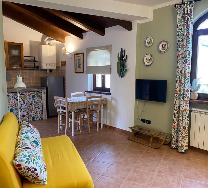 a living room with a yellow couch and a kitchen at La Corte di San Rocco in Murazzano