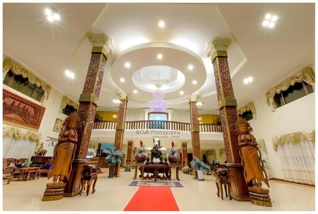 a lobby with a table and chairs in a building at Vy Chhe Hotel in Battambang
