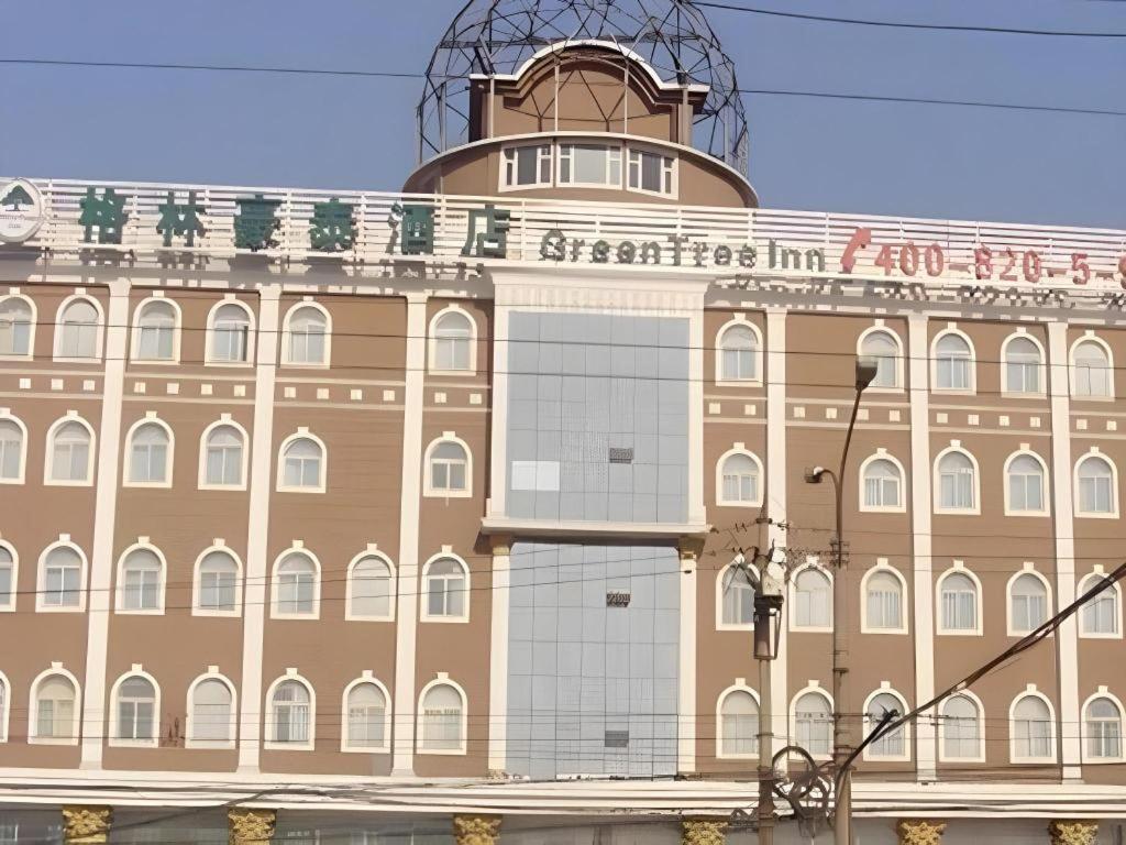 un grand bâtiment avec une enseigne sur le côté dans l'établissement GreenTree Inn Taiyuan Xinghua Street, à Taiyuan