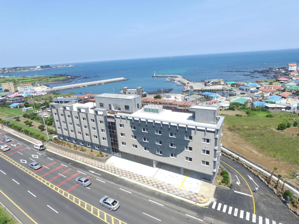 un edificio sul lato di una strada vicino all'oceano di The Stay Century Hotel a Jeju