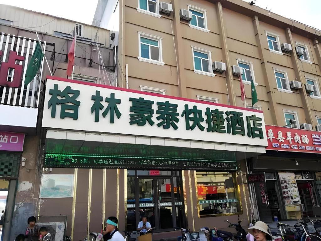 a sign for a store in an asian city at GreenTree Inn Heze Mudan Road Bus Terminal Station Express Hotel in Heze