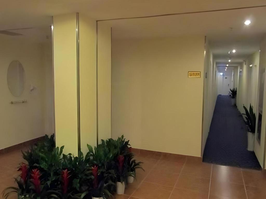 an empty hallway with plants in a building at 7 Days Premium Suzhou Mudu Ancient Town in Suzhou
