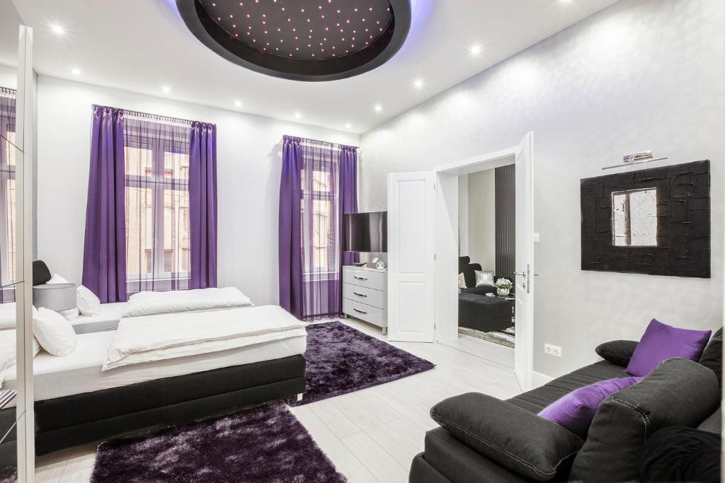 ブダペストにあるOpera Luxory Suiteの紫色のカーテンとソファ付きのリビングルーム