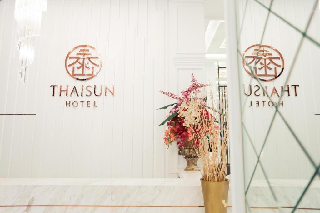 a storefront with a vase of flowers in a window at Thaisun Bangkok Hotel in Bangkok
