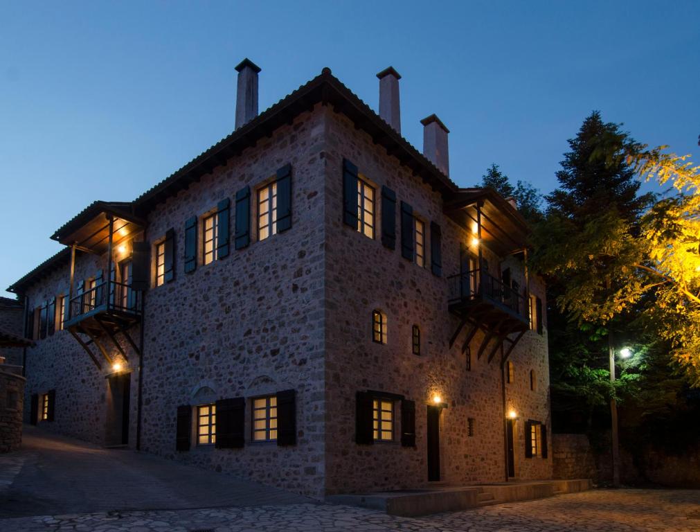un vecchio edificio in pietra di notte con luci accese di Hotel Archontiko Anyfanti a Zátouna